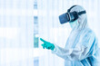 © Arunporn - ASIAN medical staff wear PPE suit and medical glove with VR glasse touching the air to monitor patient health