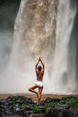 Sticker - Beautiful woman doing yoga near a waterfall in Bali