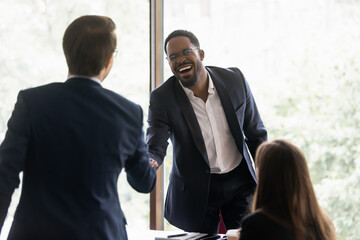 Canvas Print - Happy diverse business leader and client shaking hands on meeting. Confident lawyer, bank employee, broker giving handshake to investor, partner. Employer hiring job candidate after interview