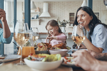 Happy family communicating and smiling while having dinner together