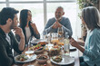© gstockstudio - Happy multi-generation family communicating and smiling while having dinner together