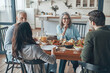 © gstockstudio - Happy multi-generation family communicating and smiling while having dinner together