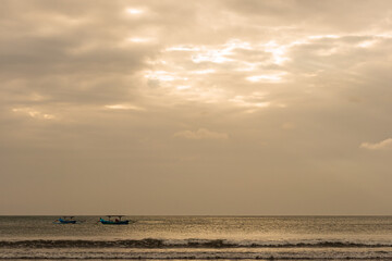 Two Indonesian traditional fishing boats on the sea at dusk