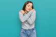 © Krakenimages.com - Young beautiful woman wearing casual turtleneck sweater hugging oneself happy and positive, smiling confident. self love and self care