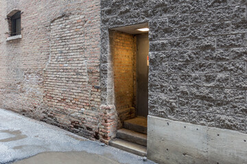 Soft light illuminating doorway in alley with vintage brick building