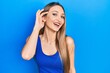 © Krakenimages.com - Young blonde girl doing listen gesture with hand on ear smiling and laughing hard out loud because funny crazy joke.
