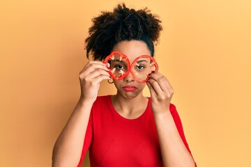 Poster - Young african american girl holding red pepper as a glasses depressed and worry for distress, crying angry and afraid. sad expression.