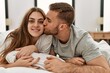 © Krakenimages.com - Young caucasian couple smiling happy and kissing on the bed at home.