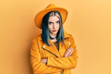 Sticker - Young modern girl wearing yellow hat and leather jacket skeptic and nervous, disapproving expression on face with crossed arms. negative person.