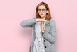 © Krakenimages.com - Young caucasian woman wearing business style and glasses doing time out gesture with hands, frustrated and serious face