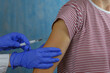 © Irina - Close up of the hand of a general practitioner holding a vaccine injection. Flu shot. Doctor vaccinates the patient's shoulder