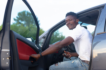 Wall Mural - A happy African-American man holds the car keys. Car sales and rentals