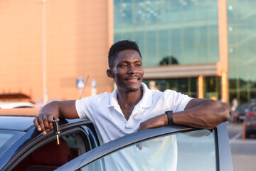 Wall Mural - A happy African-American man holds the car keys. Car sales and rentals