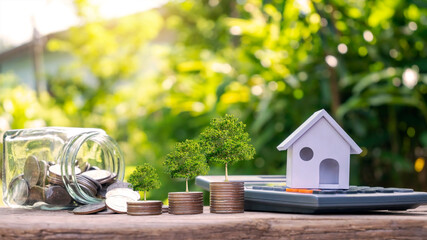 Model house on calculator and tree growing on a pile of credit concept coins. Real Estate, Finance, Mortgage, Residential Real Estate