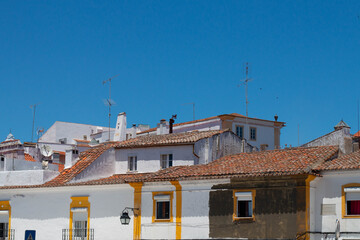 Evora, Portugal: 09/05/2021: Street view with beautiful old residential buildings in Evora city in Portugal with people around making their daily life