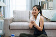 © PR Image Factory - fitness sport training technology lifestyle concept. smiling woman with smartphone and bluetooth earphones enjoy music with towel on neck. joyful lady listen song in wireless headphones on yoga mat
