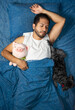 © Narayan - latin man sleeping in bed with pig stuffed animal and his dog, sleep concept