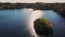Scandinavian Atmosphere With Forest Landscape And Calm Lake With Islet.  Aerial Backward View