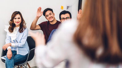 Wall Mural - Businesswoman coach speaker presentation and discussing meeting strategy sharing idea.Creative casual business people showing hand to answer question in conference seminar at hall.presentation