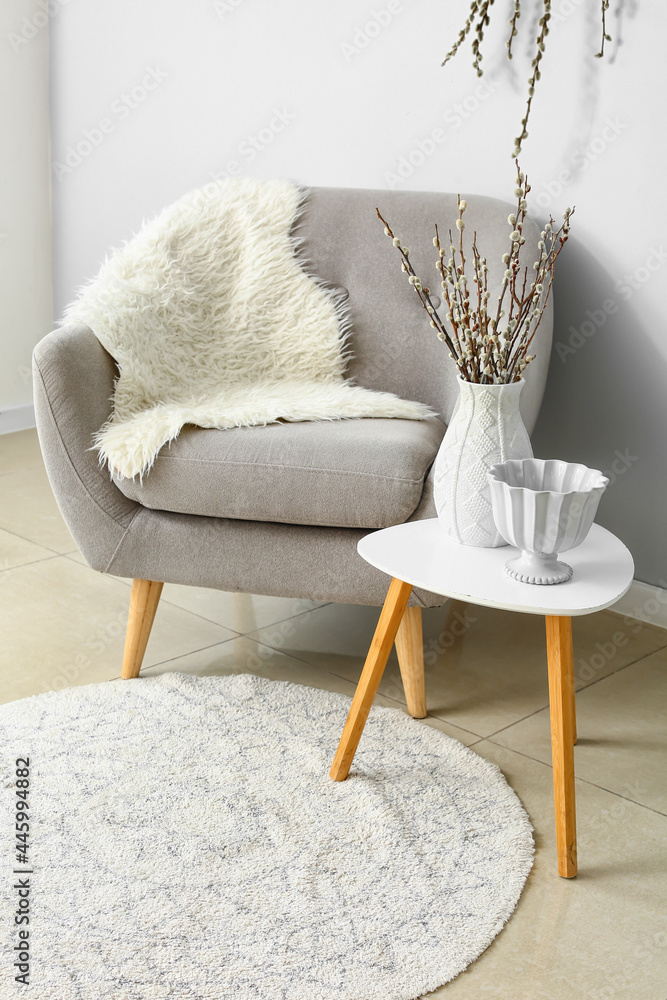 Interior of room with cozy armchair and willow branches