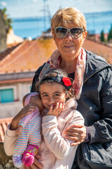 Sticker - Happy elderly woman visiting city embracing her grand daughter.