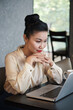 © DragonImages - Pensive beautiful businesswoman reading report or article on laptopscreen