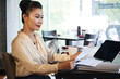 © DragonImages - Beautiful elegant businesswoman sitting at restaurant table and reading report or agreement