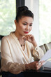 © DragonImages - Serios pensive female entrepreneur reading document with important information
