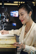 © DragonImages - Smiling professional banquet manager reading restaurant menu and taking notes in planner
