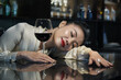 © DragonImages - Elegant woman fell asleep at bar in restaurant after drinking couple glasses of red wine