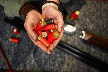 Male hunter hands holds cartridges in gun store