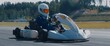 Front view of teenager professional racer driving his go kart on a race track. Shot with 2x anamorphic lens