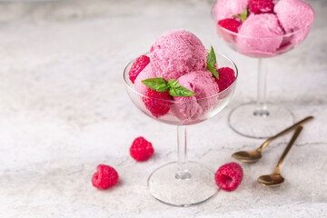 Sticker - Raspberry ice cream with fresh raspberries in a glass bowl on a stone surface. Two portions. Close-up, selective focus. Copy space.