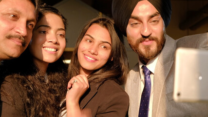 Poster - South Asian business colleagues pose together making a victory sign on a mobile phone camera