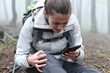 © PheelingsMedia - Injured trekker checking smart phone asking for help