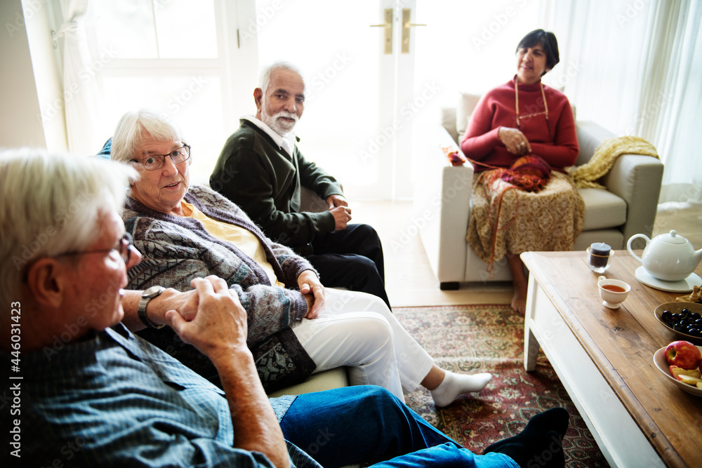 Senior people sitting together in a living room - obrazy, fototapety, plakaty 
