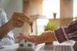 © David - Close up view Business hand of property realtor, landlord giving key house to buyer ,tenant,concerning mortgage loan offer for and house insurance Real estate concept.