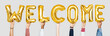 © Rawpixel.com - Hands holding balloons spelling Welcome