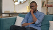 © stockbakers - Young African Man Sitting and Crying on Sofa