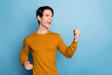 Sticker - Photo of hooray yell brunet millennial guy hands fists wear brown sweater isolated on blue color background