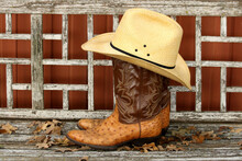 Straw Cowboy Hat Setting On Top Of Cowboy Boots