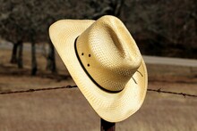 Straw Cowboy Hat Hanging On Fence Close-up