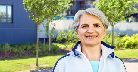 Sticker - fitness, sport and healthy lifestyle concept - smiling sporty senior woman over city street background