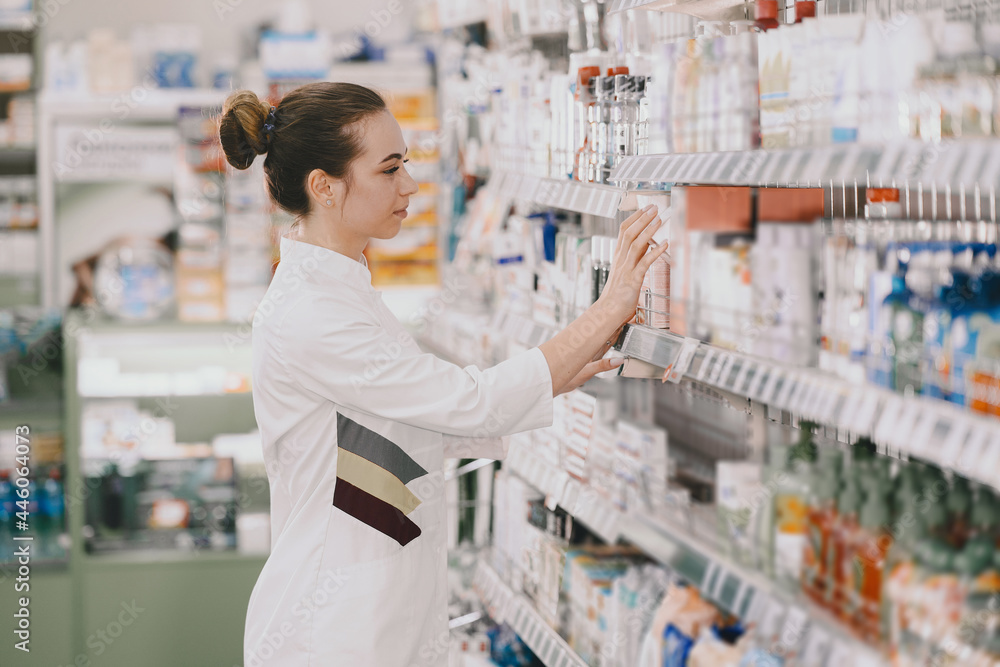 Woman pharmacist checking medicine in pharmacy - obrazy, fototapety, plakaty 