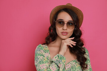 Poster - Beautiful young woman with straw hat and stylish sunglasses on pink background