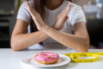 Wall Mural - women consider to stop eat sweet food have many sugar for good health and lose weight