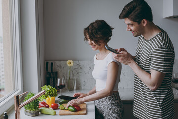 Wall Mural - Young side view couple two woman man 20s in casual t-shirt clothes prepare vegetable salad take photo by mobile cell phone cook food in light kitchen at home together Healthy diet lifestyle concept.