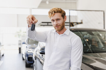 Wall Mural - Man happy customer male buyer client wearing classic suit shirt giving keys fob chooses auto want buy new automobile in car showroom vehicle salon dealership store motor show indoor. Sales concept