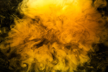 Wall Mural - Abstract liquid art, yellow smoke bomb on black background, amber color acrylic paints under water