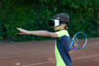 © Anna - Boy in VR glasses with racquet is preraring to make tennis kick with help of virtual trainer on online lesson. Training with help of cyber technologies.
